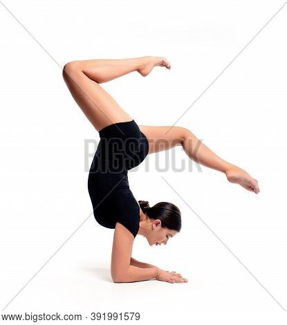 A Young Beautiful Female Gymnast In Sportswear Performs A Handstand. Training, Element Of Gymnastics