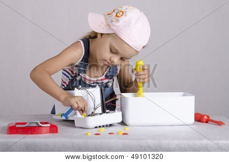 Girl repairs toy small home appliances