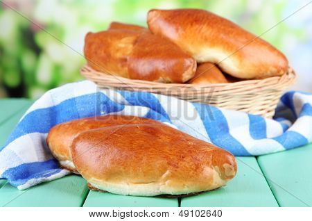 Empanadillas al horno frescos en cesta de mimbre, sobre fondo brillante