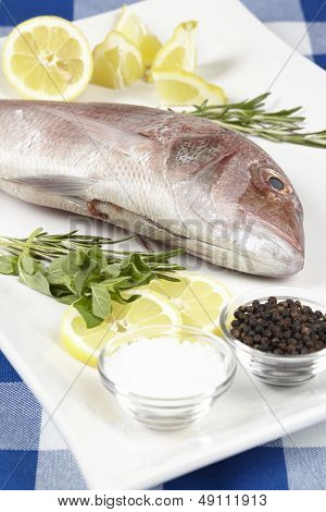 A Red Sea Bream With Spices, Lemon Slices And Herbals