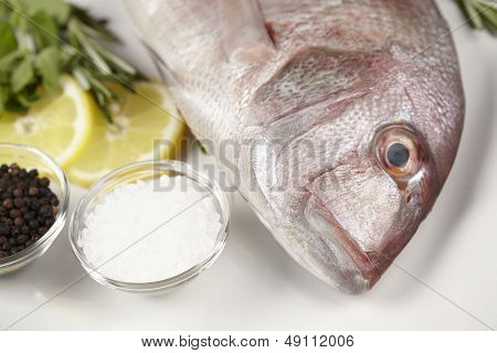 A Red Sea Bream With Spices, Lemon Slices And Herbals