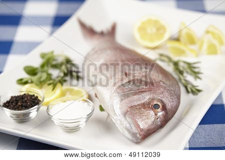 A Red Sea Bream With Spices, Lemon Slices And Herbals