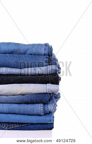 stack of different kind of blue jeans on white background