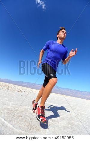 Ejecuta a hombre de atleta deporte corriendo en la pista en el desierto. Corredor fitness masculino en entrenamiento de sprint tr