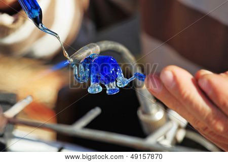 Heikle Arbeit des Gebläses Glas. Das Künstler-Glas-Gebläse erzeugt eine anmutige kleine Figur von ein ele