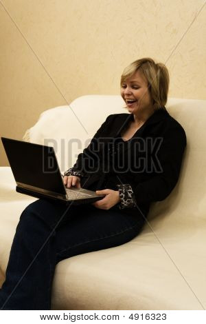 Griner kvinde med Computer sidder på en Sofa