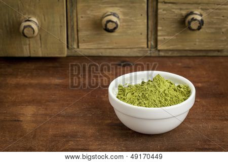 Moringa list prášek v malé misce se rustikální skříň