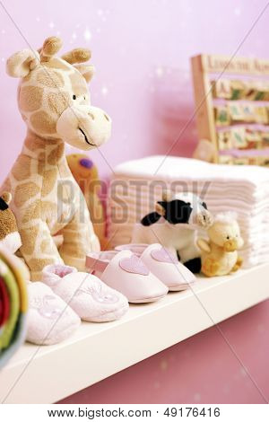 Scarpe giocattoli farciti e pannolini sullo scaffale nella stanza del bambino