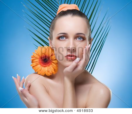 Portrait schöne Frau mit der orange Blume.