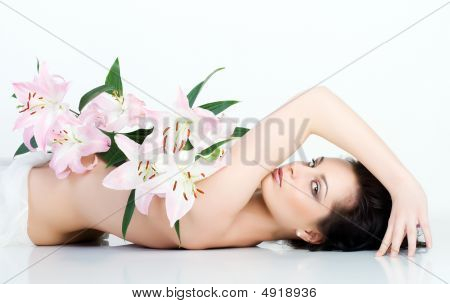 schöne Frau mit der rosa Blume auf der Brust.