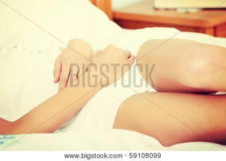 Young woman stroking her belly becouse of bellyache