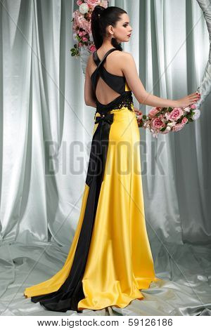 Beautiful sexual brunette in n evening dress with the hoop with pink flowers