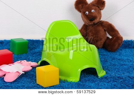 Green potty on home interior background