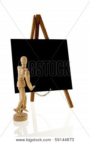 Wooden Teacher In Front Of Blackboard