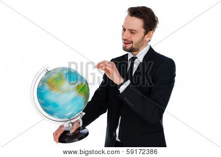 Businessman spinning a globe of the world as he plans his annual vacation or envisages new global markets for the business, isolated on white