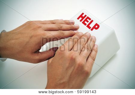 a man pressing a giant help key with his hands