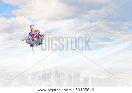 Young woman sitting on chair and meditating