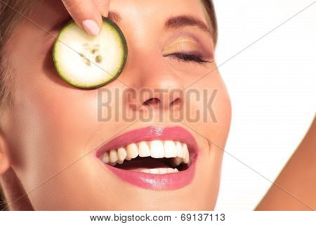 Young Beautiflul Smiling Girl Applying A Cucumber Beauty Treatment