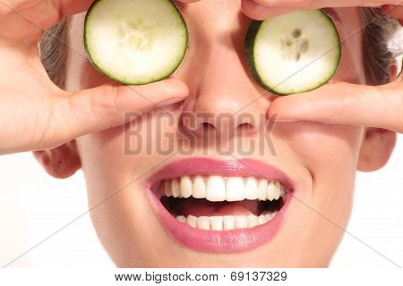 Young Beautiflul Smiling Girl Applying A Cucumber Beauty Treatment