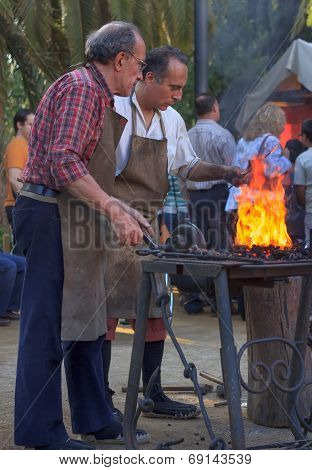 Blacksmiths Working On Metal