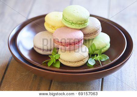 Colorful macaroons on brown plate