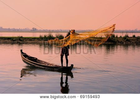 AMARAPURA, MYANMAR - DECEMBER 31: An unidentified man fishes in a lake on December 31, 2011 in Amara