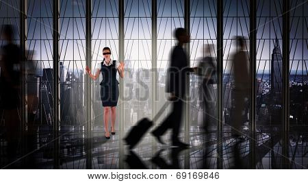 Redhead businesswoman in a blindfold against room with large window looking on city