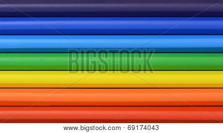 Close up of rainbow colored wax crayons in rows