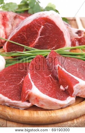 raw meat : fresh beef pork big rib and fillet with garlic and green stuff on wood isolated over white background