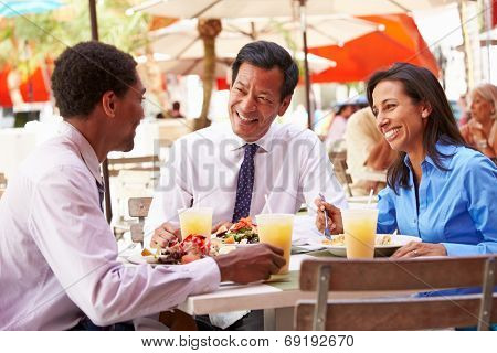 Three Businesspeople Having Meeting In Outdoor Restaurant