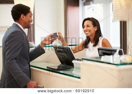 Businessman Checking In At Hotel Reception Front Desk