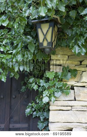 detail of a stone wall, ancient door and lantern
