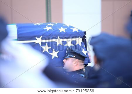 Flag-draped coffin carried outside