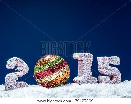 Frosted 2015 New Year digits and glistering ball over dark blue background