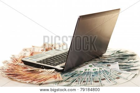 Laptop on large pile of bills five thousandth