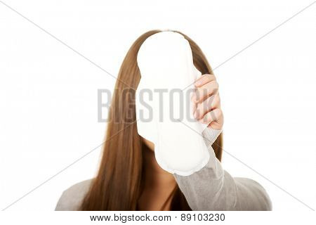 Tren woman with menstruation pad covering face.