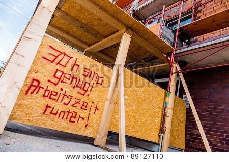 at a construction site is a sign of aufschrifft: thirty hours are enough. symbolic photo for shorter working hours