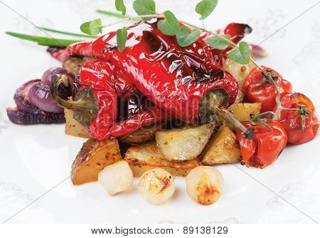 Roasted red peppers with potato and vegetables on white plate
