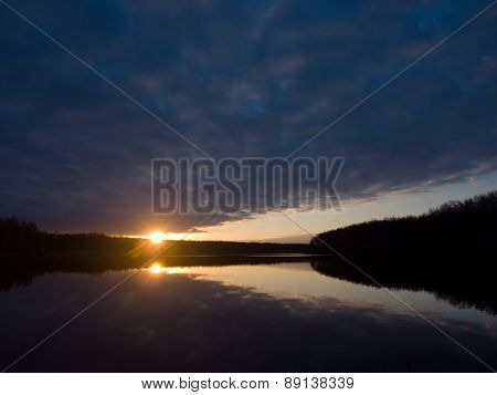 Beautiful sunrise over the forest lake