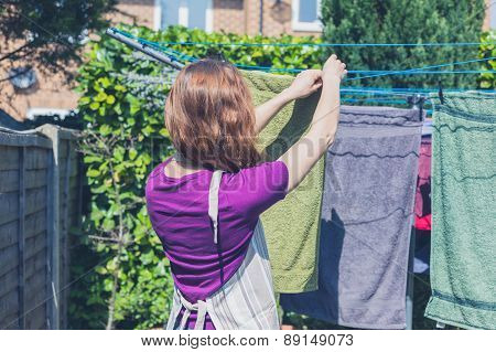 Woman Hanging Her Laundry In Garden