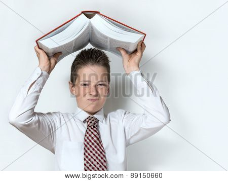 Displeased schoolboy throws big red book