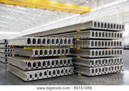 Stack of precast reinforced concrete slabs in a house-building factory workshop