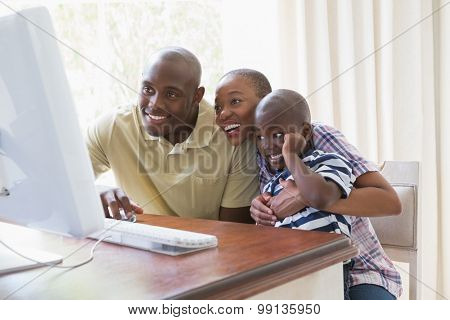 Happy smiling family chatting with computer at home