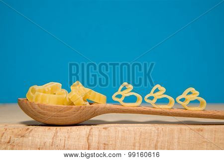 Pasta In The Form Of Animals And A Spoon On A Blue Background