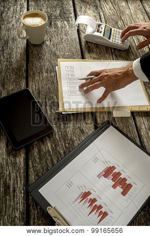 Businessman Calculating Sales On The Table