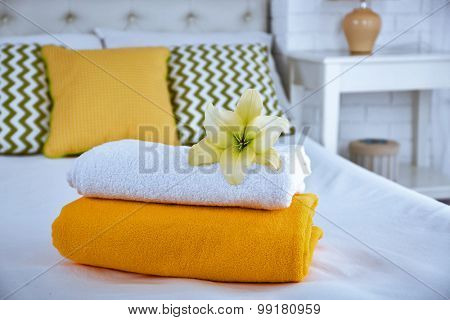 Freshly laundered fluffy towels in bedroom interior