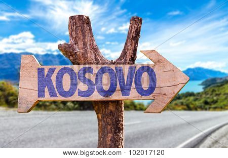 Kosovo wooden sign with road background