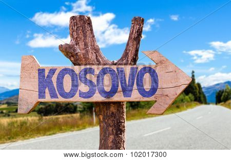 Kosovo wooden sign with road background