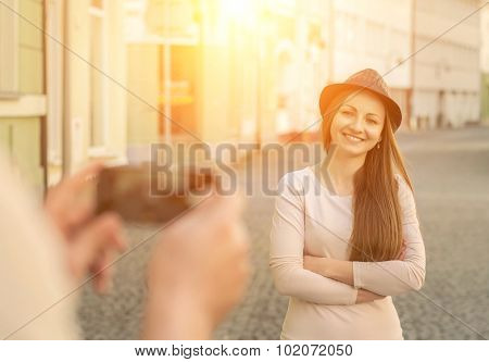 Touristic couple shooting on the modile phone at the city streets under sunlight.