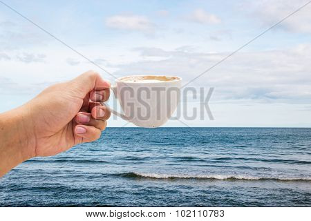Hand Hold Coffee Cup On Ocean